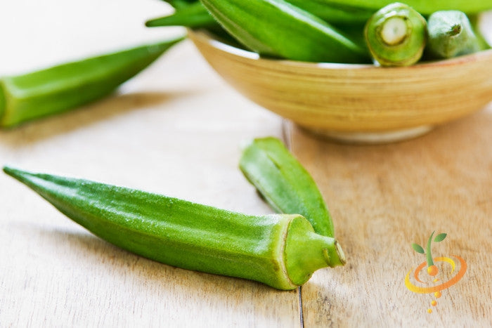 Fresh green Okra Clemson Spineless pods on wooden surface and in a bowl